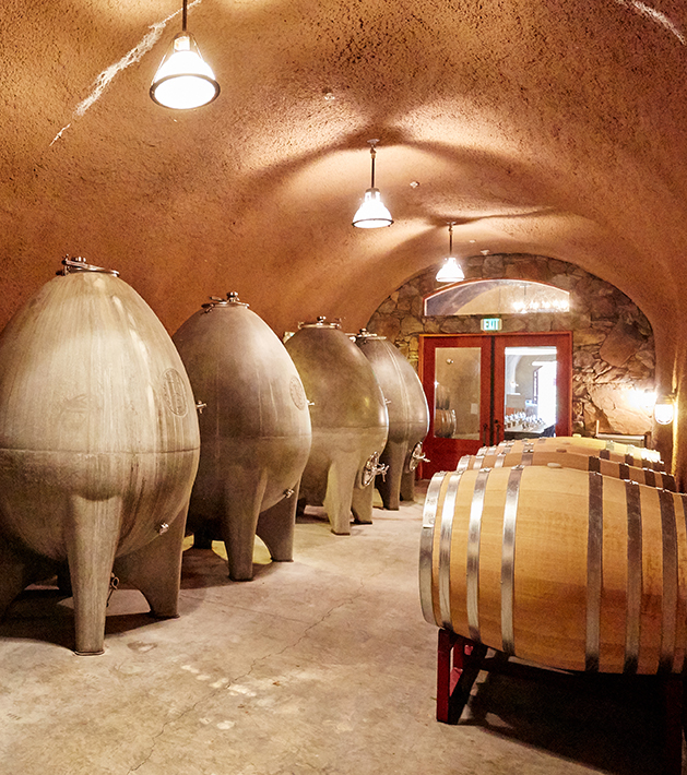 barrels of wine and concrete eggs in a wine cave.