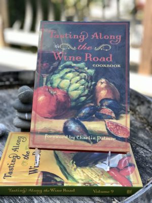 Tasting Along the Wine Road Cookbook volume 7 attractively displayed on a barrel
