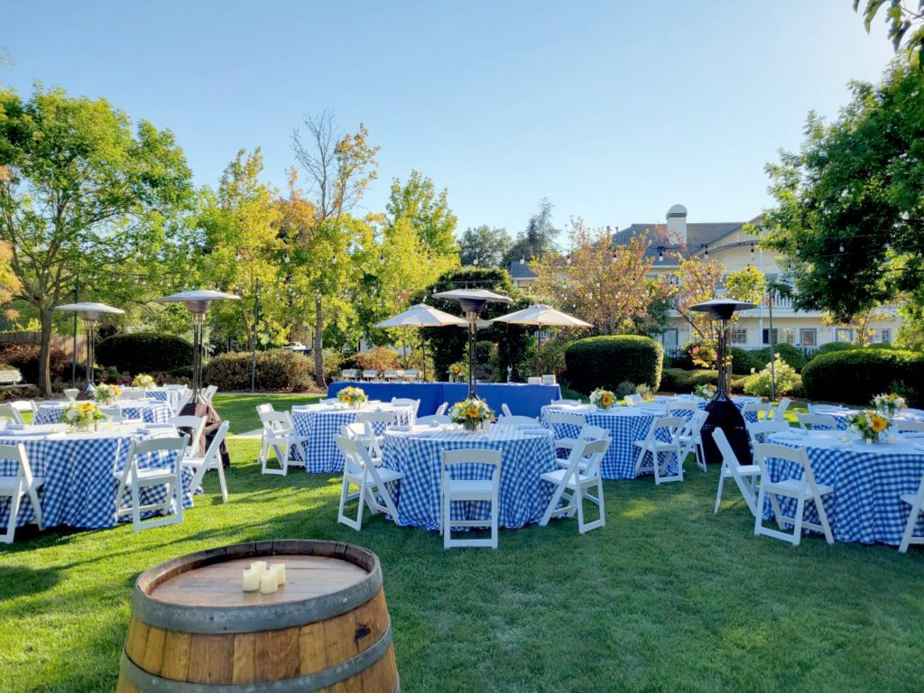 The gardens of Geyserville Inn set up for an afternoon wedding with blue checkered table cloths.